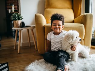 Child on floor with white dog.