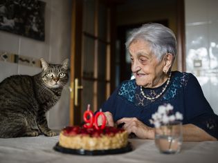 Senior woman celebrating ninetieth birthday with her cat