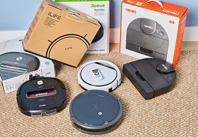 Four robot vacuums on the floor for the pet hair vacuum test