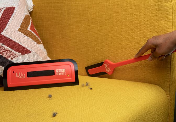 Closeup person using Lilly Detailer Pro Kit on yellow couch